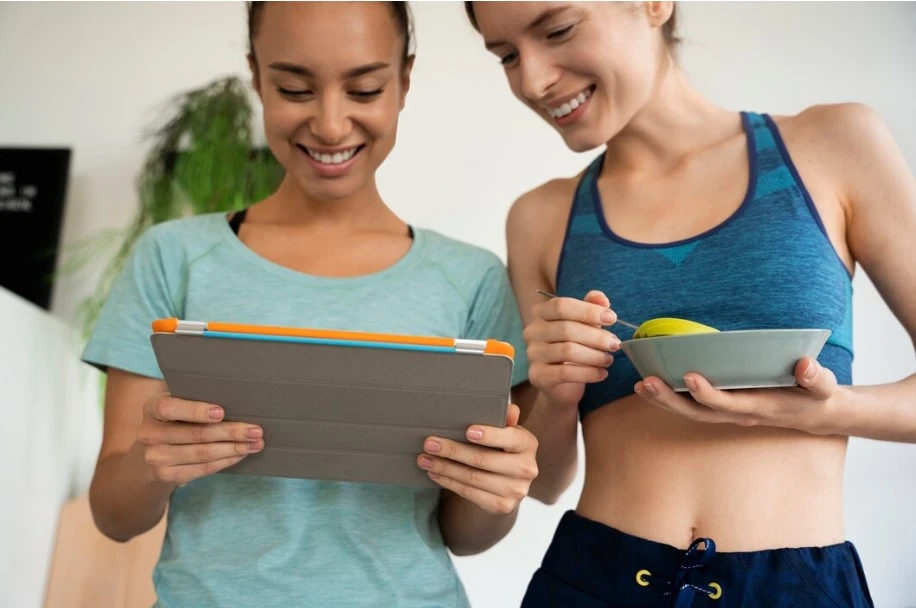 10 Best Strategies for Weight Loss Maintenance weight loss maintenance- two women holding a tablet and a bowl of food