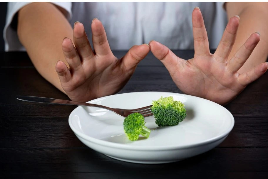 10 Best Strategies for Weight Loss Maintenance weight loss maintenance-a person's hands over a plate of broccoli